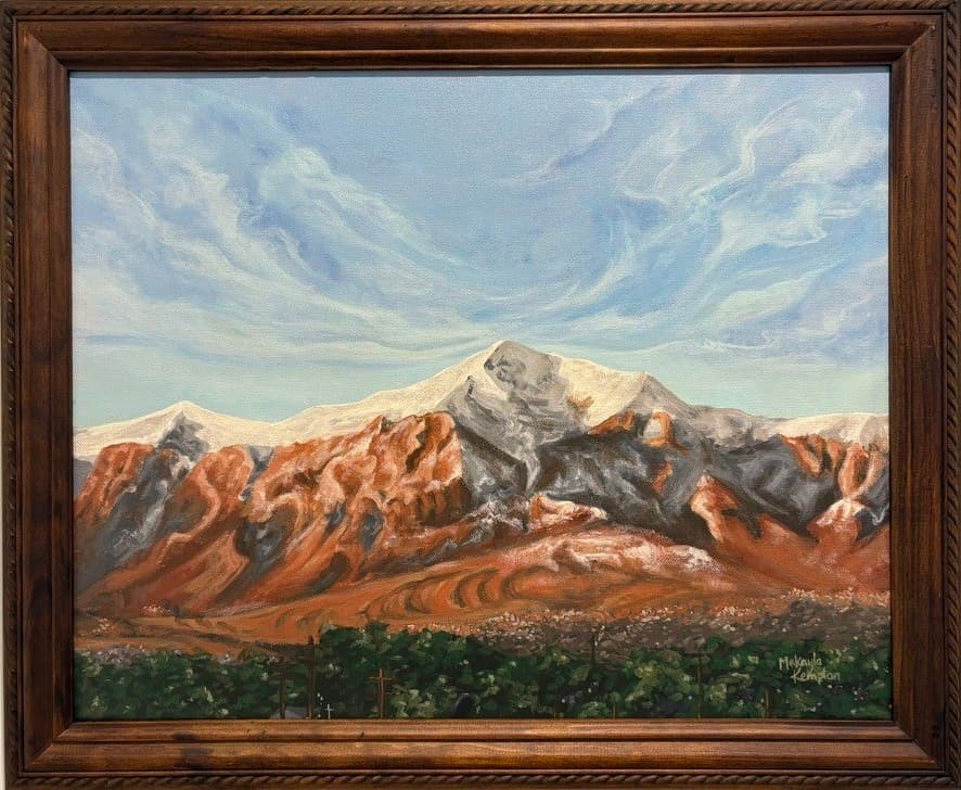 A framed acrylic painting of a snow-capped mountain under a streaked blue sky